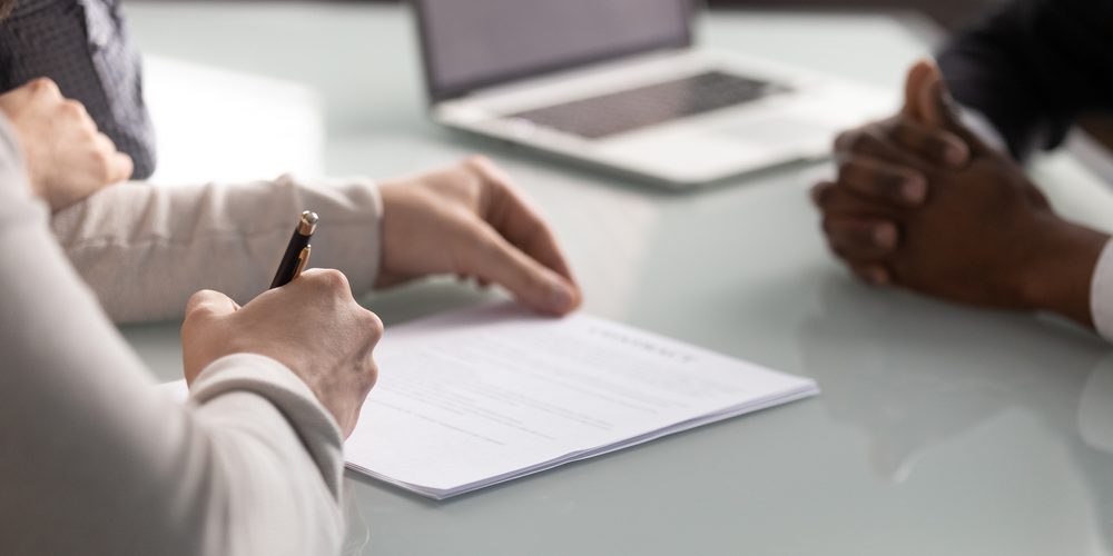 Close,Up,Diverse,Hands,Sign,Up,Document,At,Meeting.,Client