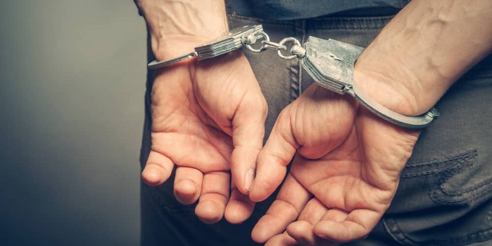 Male hands in handcuffs.
