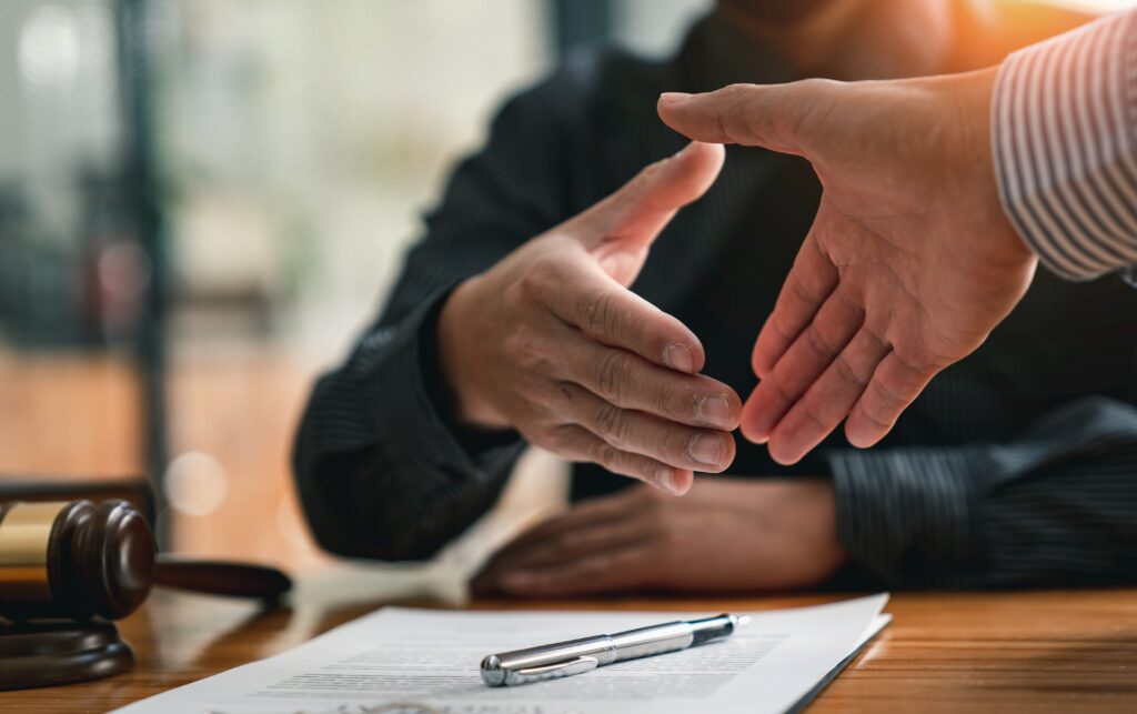 Lawyers shake hands with business people to seal a deal with partner lawyers. or a lawyer discussing contract agreements, handshake concepts, agreements, agreements